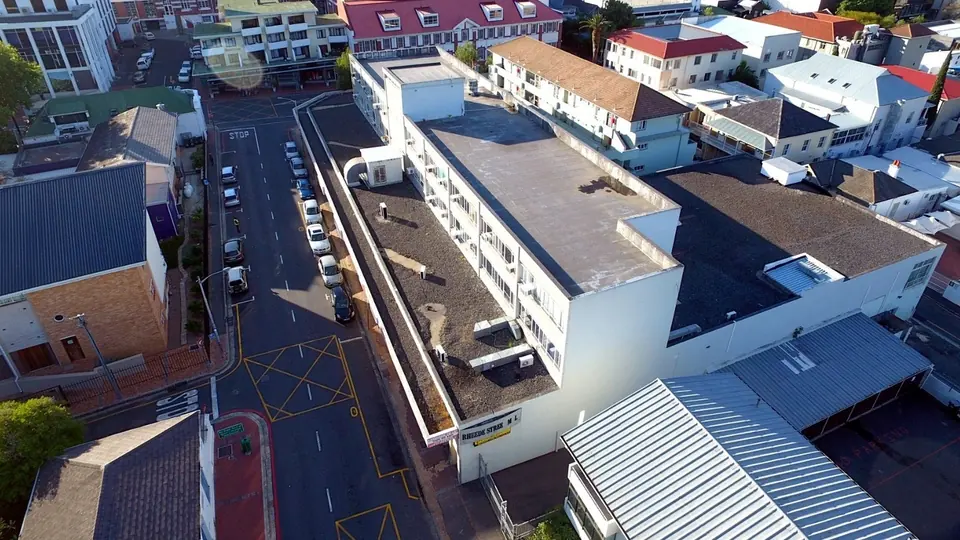The same corner before: a tired cream commercial block